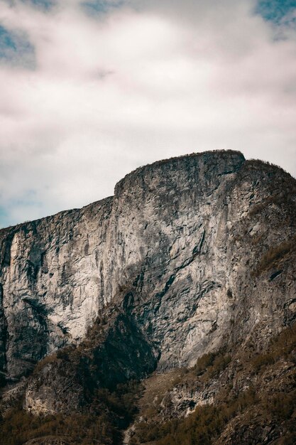 Une montagne avec un ciel gris et un nuage blanc