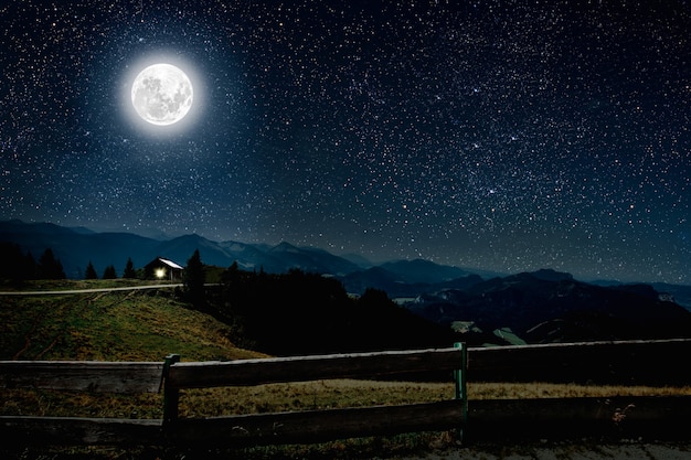 Montagne. ciel nocturne avec étoiles et lune et nuages