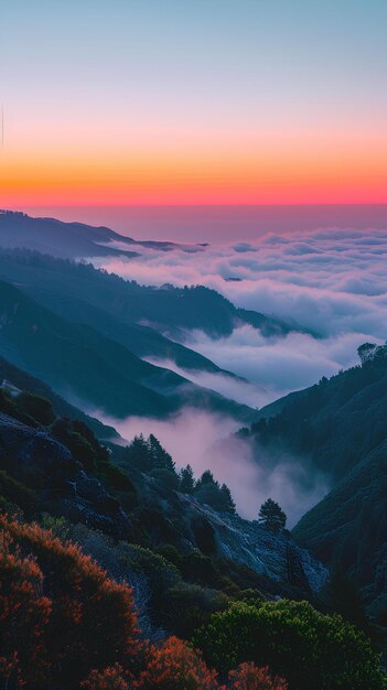 Une montagne avec un coucher de soleil en arrière-plan et une vallée brumeuse en dessous avec une tour de radio dans le