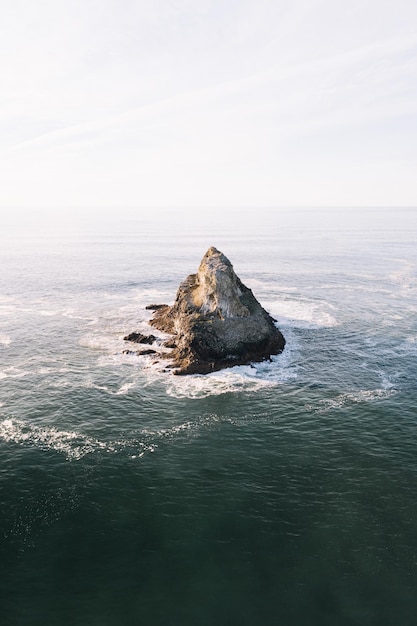 Une montagne dans la mer contre le ciel