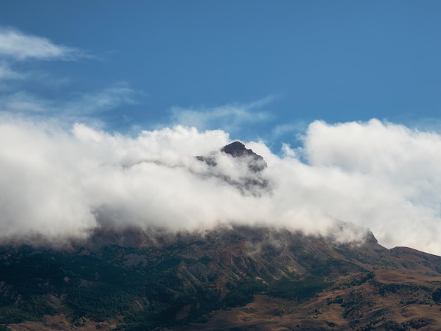 Montagne dans les nuages blancs Paysage mystique avec de beaux rochers pointus dans des nuages bas Beau paysage de montagne brumeux au bord de l'abîme avec des pierres pointues