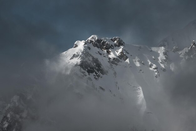 Photo une montagne enneigée dans les nuages