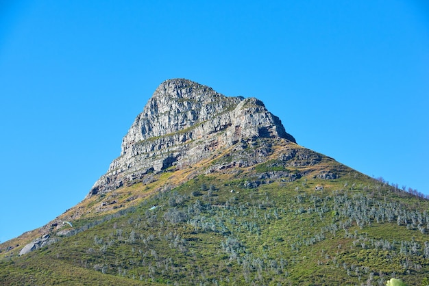 Montagne Lions Head avec un ciel bleu et un espace de copie Belle vue ci-dessous d'un sommet de montagne rocheux recouvert de beaucoup de végétation verte luxuriante dans une destination touristique populaire au Cap en Afrique du Sud