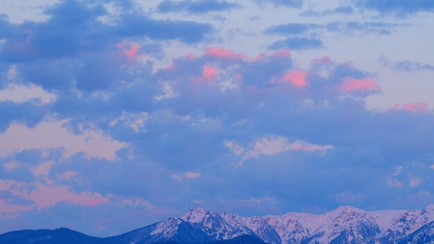 Photo montagne avec des nuages roses et violets beau coucher de soleil au point de vue timelapse