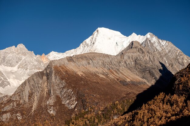 Montagne sacrée avec la lumière du soleil et le ciel bleu en tibétain à la réserve naturelle de Yading, Daocheng, Chine