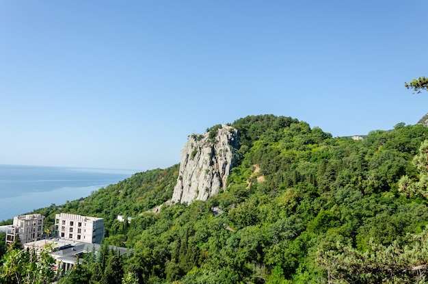 Photo une montagne avec vue sur la mer et un bâtiment dessus