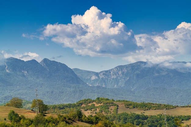 Montagnes couvertes de forêt verte dense, tours de transmission d'énergie