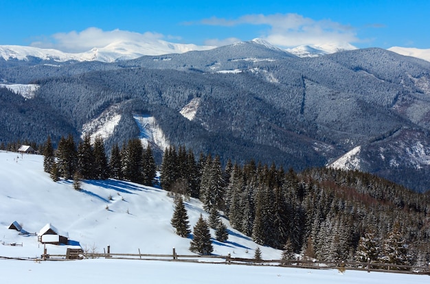 Montagnes enneigées d'hiver et ferme solitaire