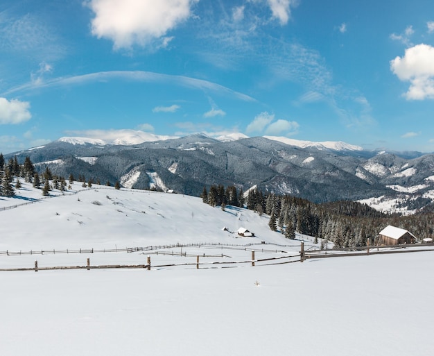 Photo montagnes enneigées d'hiver et ferme solitaire