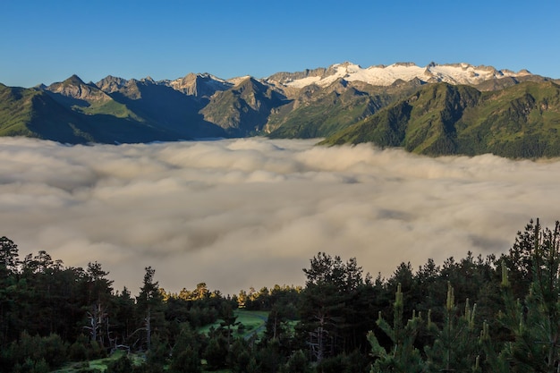 Montagnes enneigées sur les sommets avec mer de nuages blancs