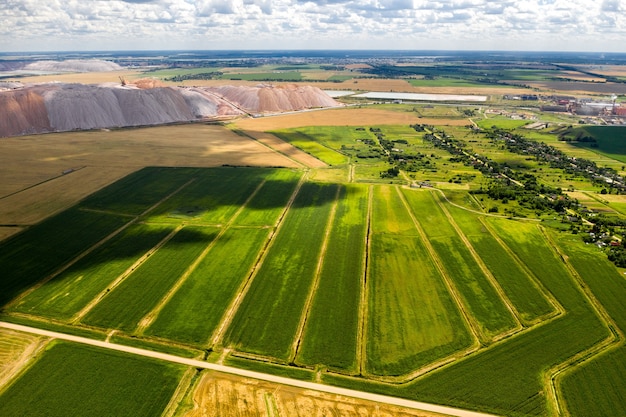 Des montagnes de produits pour la production de sel de potasse et un champ vert