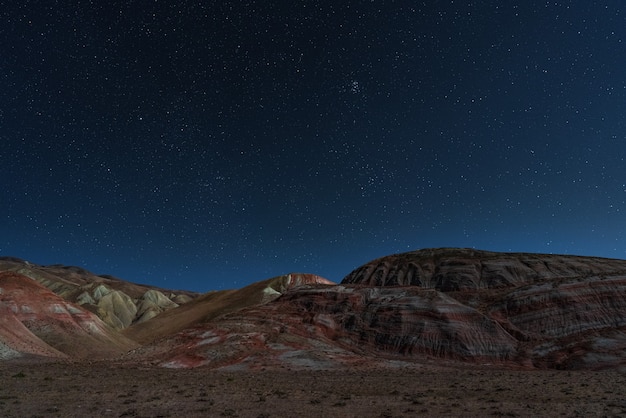 Montagnes rouges rayées étonnantes une nuit de lune