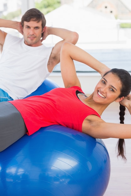 Monter le couple exerçant sur des ballons de remise en forme dans la salle