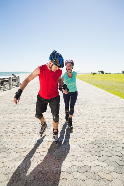 Monter le couple mature rollerblading sur la jetée