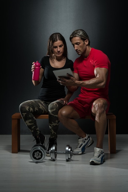 Monter un couple regardant une table numérique dans un studio sur fond noir