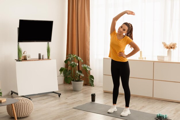 Monter la dame noire exerçant le corps de flexion qui s'étend du bras levé à l'intérieur