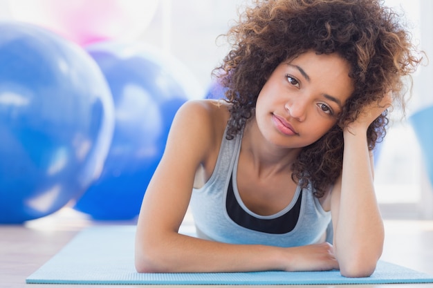 Photo monter la femme allongée sur le tapis d'exercice dans un studio de remise en forme