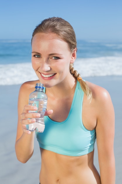 Monter la femme debout sur la plage en prenant un verre