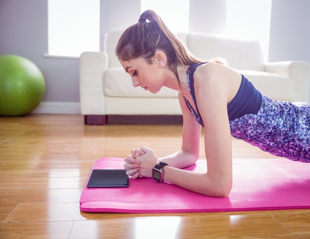 Monter la femme faisant la planche sur le tapis