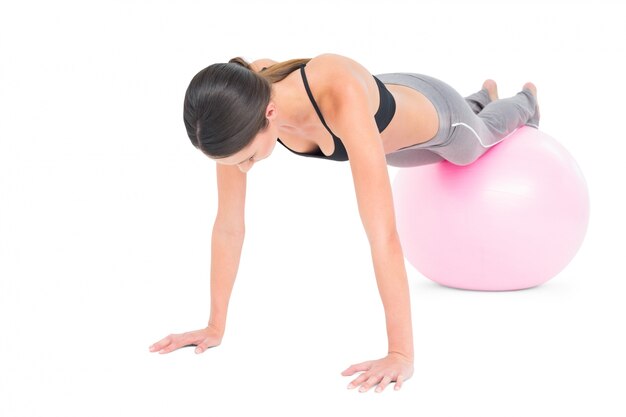 Monter la femme faisant des push ups sur ballon de fitness