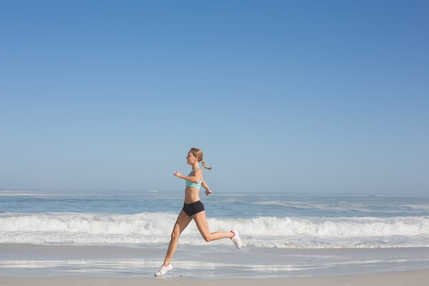 Monter la femme jogging sur la plage