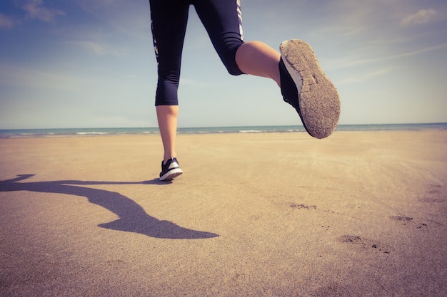 Photo monter la femme jogging sur le sable