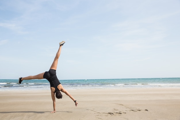 Monter la femme en train de rouler sur le sable