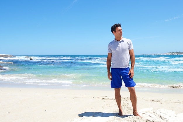 Monter l&#39;homme d&#39;âge moyen debout pieds nus à la plage