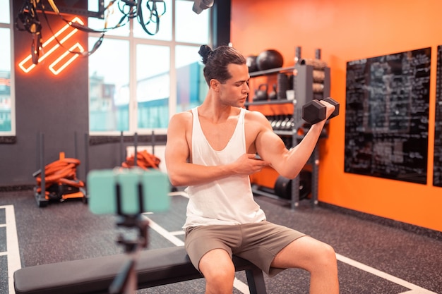 Monter l'homme bien bâti montrant son bras musclé