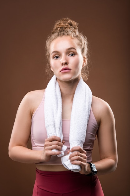 Monter la jeune sportive avec une serviette douce blanche sur son cou se reposer après l'entraînement physique