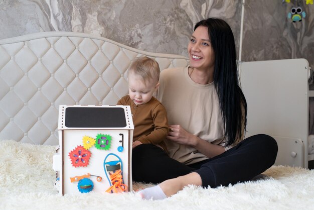 Montessori et billboard maman et petit enfant jouant avec une maison en bois