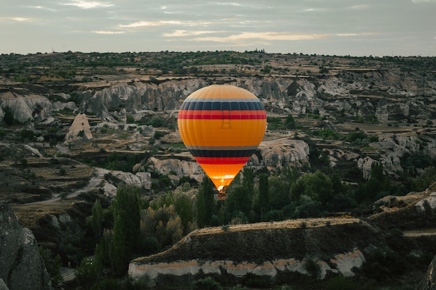 Photo montgolfière survolant la cappadoce à l'aube