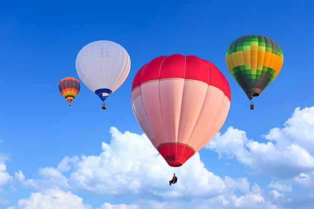 Montgolfières colorées en vol au-dessus du ciel bleu