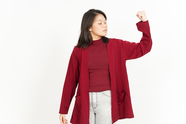 Montrant la force des bras de la belle femme asiatique portant une chemise rouge isolé sur fond blanc