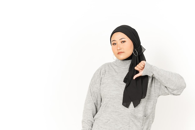 Montrant les pouces vers le bas de la belle femme asiatique portant le hijab isolé sur fond blanc