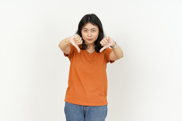 montrant les pouces vers le bas de la belle femme asiatique portant un t-shirt orange isolé sur fond blanc