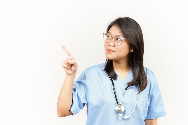 Montrant le produit et le côté pointant du jeune médecin asiatique isolé sur fond blanc