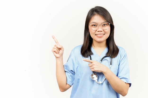 Montrant le produit et le côté pointant du jeune médecin asiatique isolé sur fond blanc