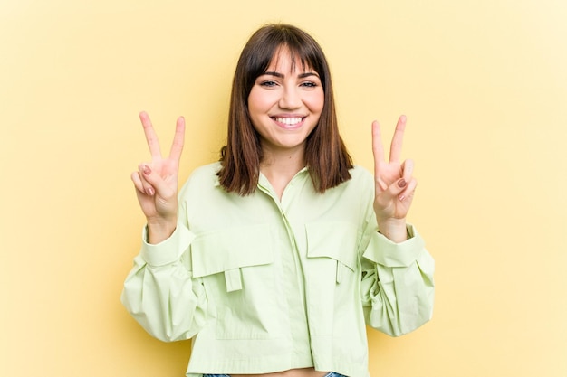 Montrant le signe de la victoire et souriant largement