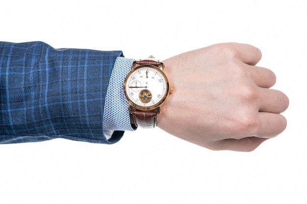 Montre-bracelet analogique portée sur la main masculine en costume d'affaires isolé sur blanc, date limite.