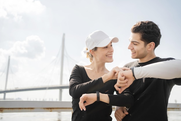 Montre-bracelet de remise en forme sur le bras Homme et femme s'entraînant dans le parc Un couple heureux