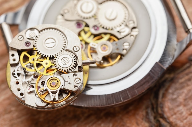 Montre démontée sur table en bois, vue du dessus