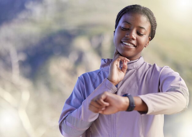 Montre intelligente de fréquence cardiaque et course avec une femme noire dans la nature pour les progrès cardio et le suivi des objectifs Temps de remise en forme et endurance avec une coureuse vérifiant le pouls avec une montre pour l'entraînement au marathon