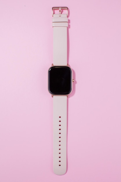 Une montre intelligente pour femme sur fond rose