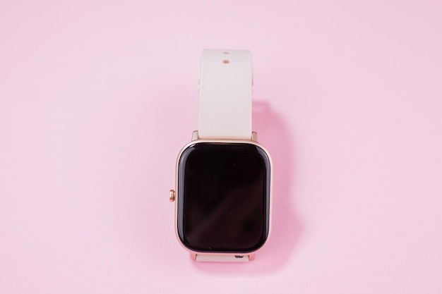 Une montre intelligente pour femmes sur fond rose