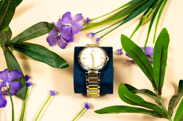 Une montre à main féminine avec des fleurs violettes sur fond rose