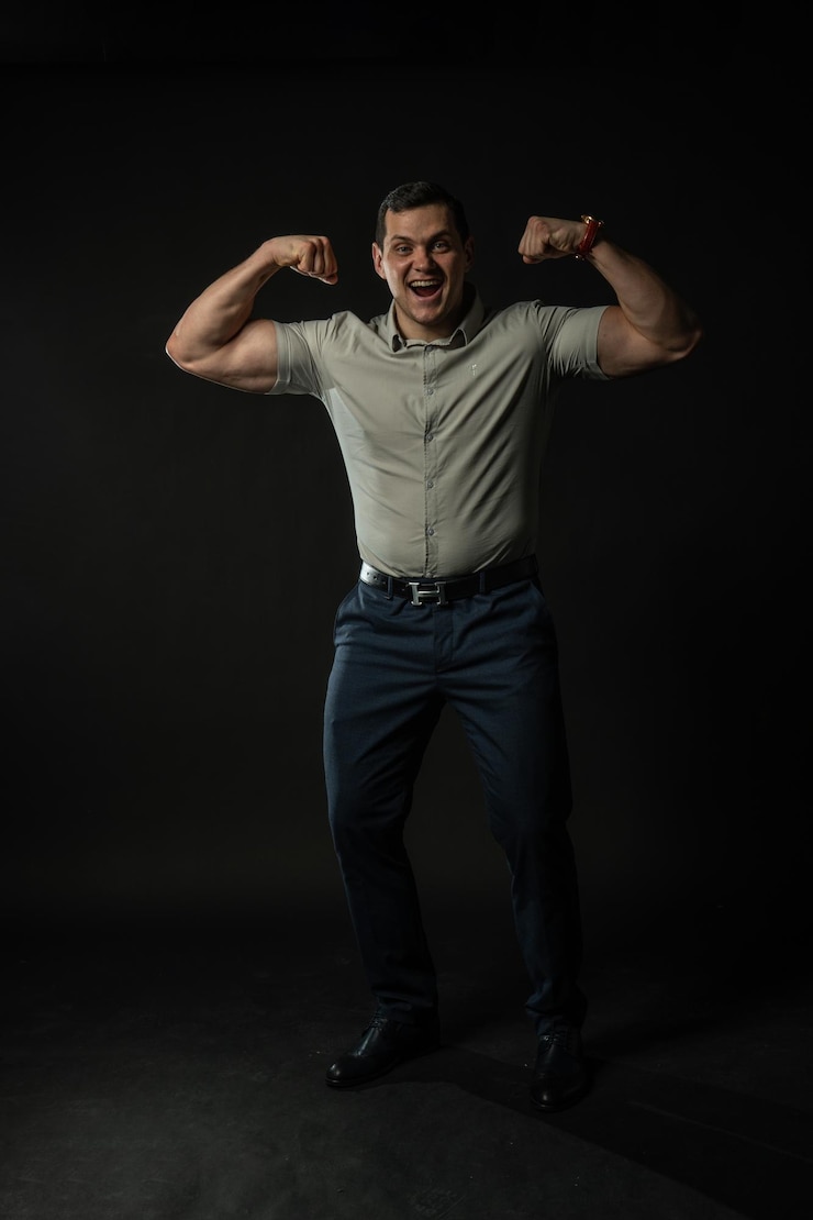 Photo montre muscle et bodybuilder souriant en chemise grise sur fond noir portrait intelligent de style