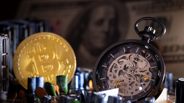 Montre de poche et bitcoin sur la carte mère de l'ordinateur.