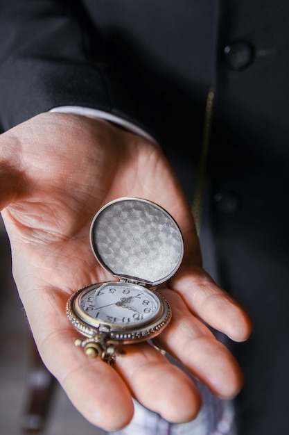 une montre de poche dans les mains d'un homme