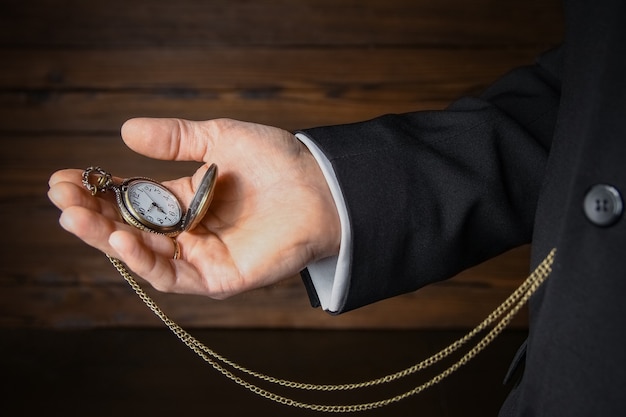 Une montre de poche entre les mains d'un homme